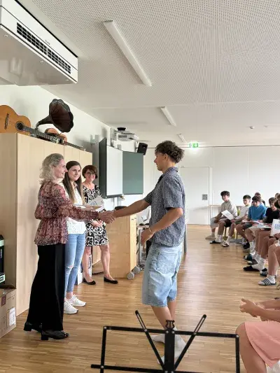 ICDL Schul-Koordinatorin Christine Haas überreicht gemeinsam mit Informatiklehrerin und Direktorin einem Schüler der SMS Altenmarkt sein ICDL Zertifikat.