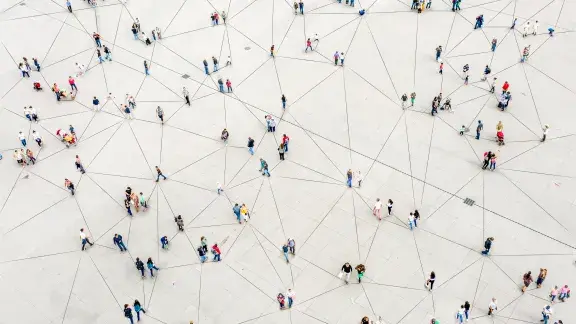 viele unterschiedliche Menschen aus der Vogelperspektive betrachtet und mit einer Visualisierung eines Netzes verbunden