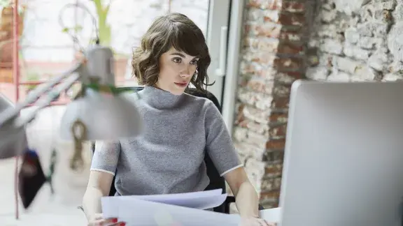 Junge Frau vor Computerbildschirm, Büro, modern, stockfoto