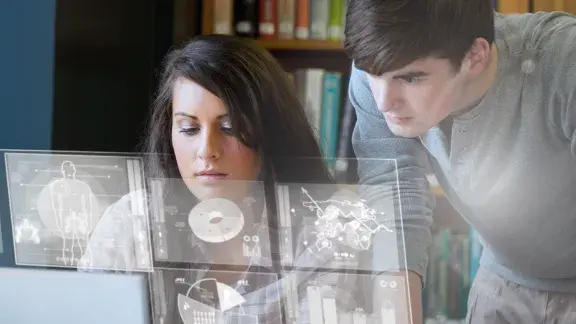 Seriöse Studentin und Student, die Diagramme auf ihrer digitalen Schnittstelle analysieren Stockfoto