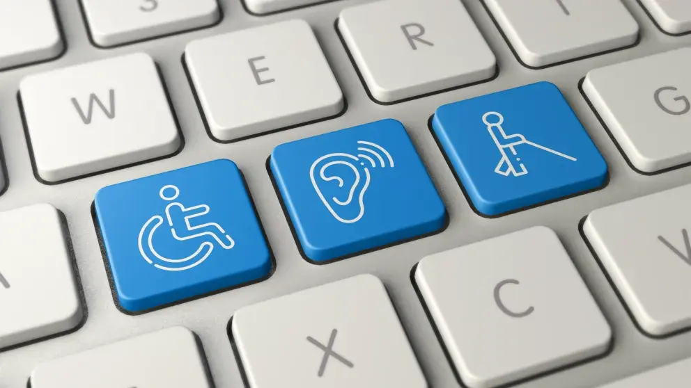 Ausschnitt zeigt eine Computertastatur mit drei extra Symbolen: einmal eine Person im Rollstuhl, einmal ein Symbol für Hörgeräte, einmal ein Symbol für Person, die mit Stock geht (Sehbehinderung)