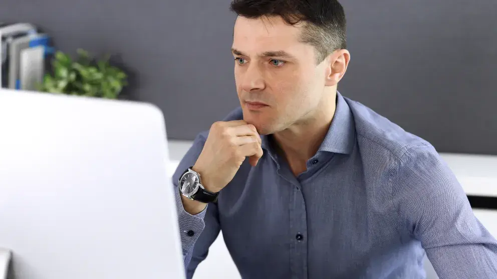 Geschäftsmann arbeitet mit Computer in modernem Büro. Headshot eines männlichen Unternehmers oder Firmenchefs am Arbeitsplatz. Business-Konzept Stockfoto