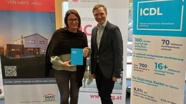 Sonja Früchtl von Hartl Haus und OCG Generalsekretär Ronald Bieber mit ICDL Roll-Up und ICDL Notizbuch im Hintergrund OCG und Hartl Haus Roll-up. C: Bernahrd Schabauer